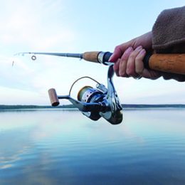 Lake Tahoe fishing with close-up of hand holding rod