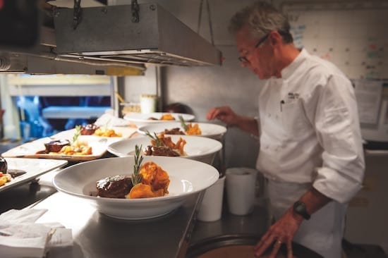 Chef Douglas Dale plating food at Wolfdale's Cuisine Unique