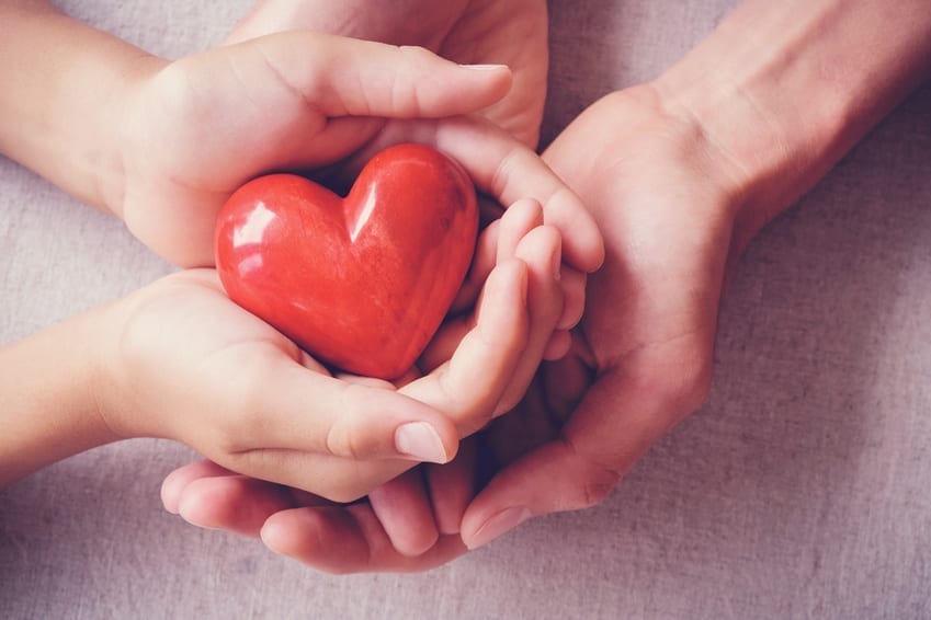 Kids and adults holding a heart