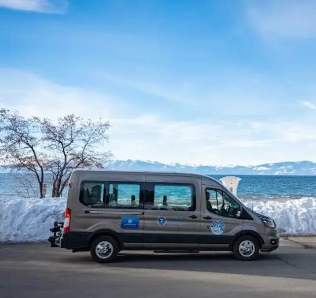TART Connect van driving by Lake Tahoe and snow covered ground